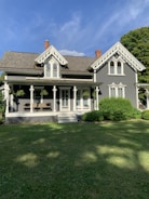 A charming Arroyo Grande craftsman-style home with a sunlit porch and lush garden.