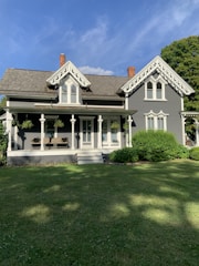 white and black wooden house on green grass field during daytime
