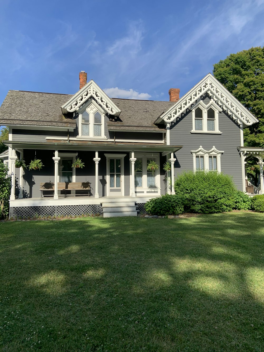 white and black wooden house on green grass field during daytime