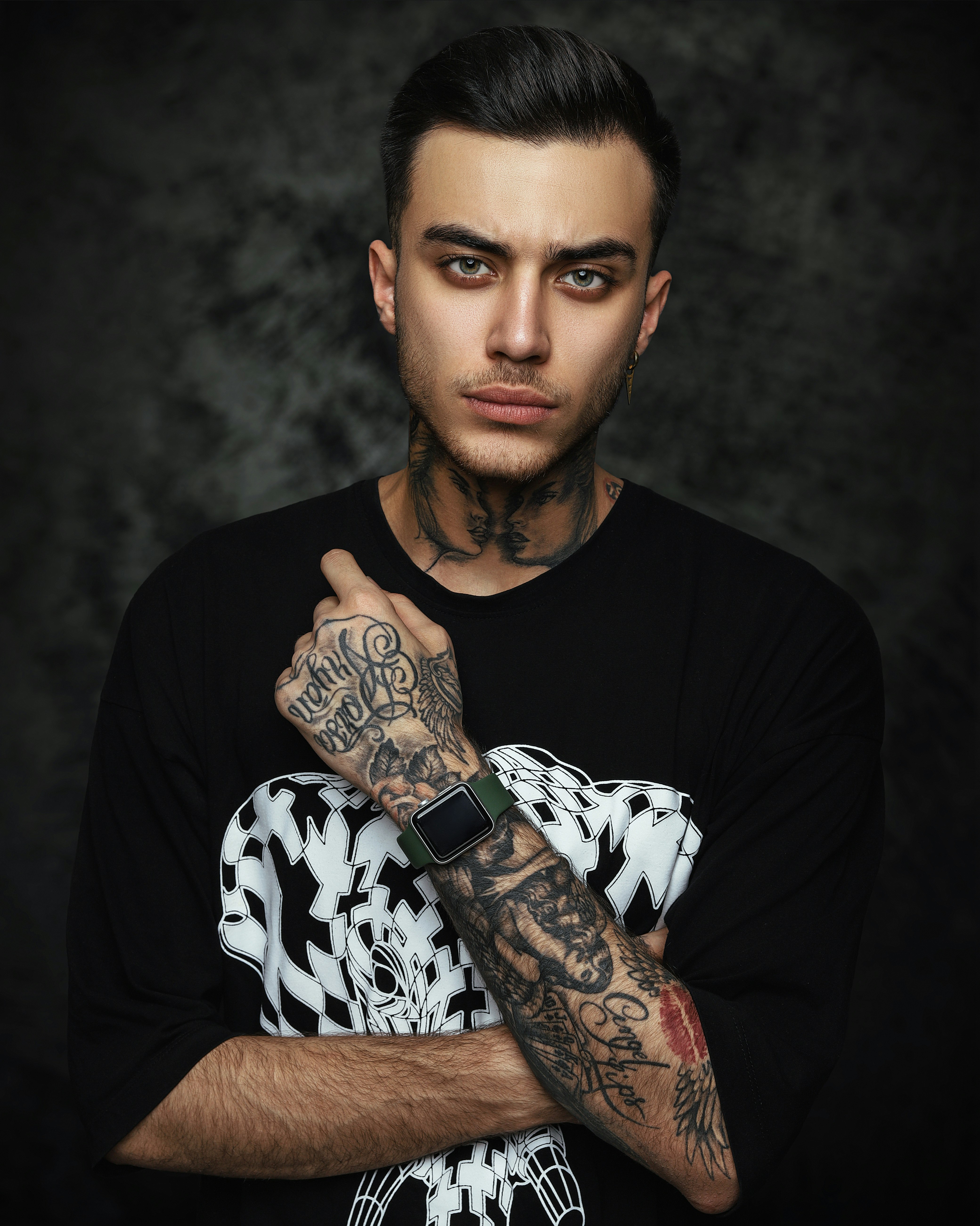 man in black crew neck t-shirt with black and white skull tattoo on his right
