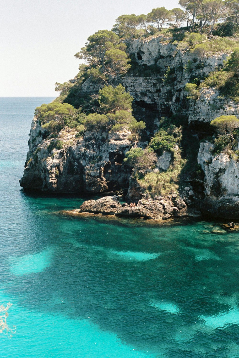 formação rochosa verde e marrom no mar azul durante o dia