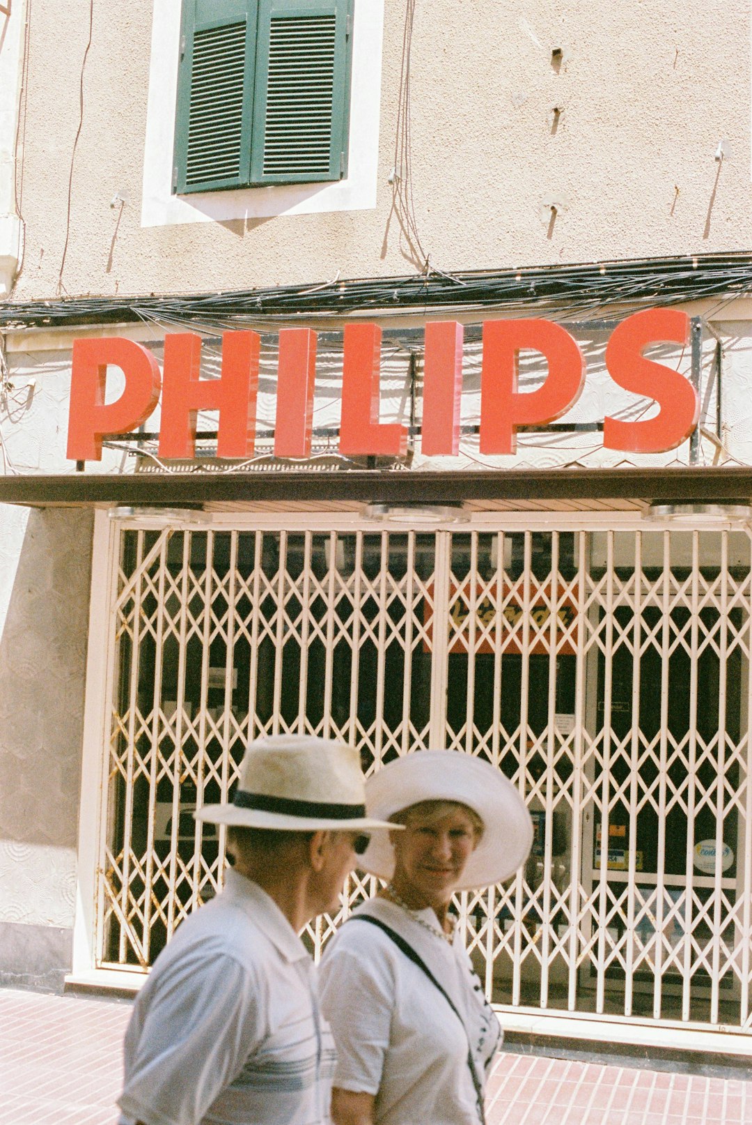 man in white hat and white dress shirt standing near red and white building during daytime