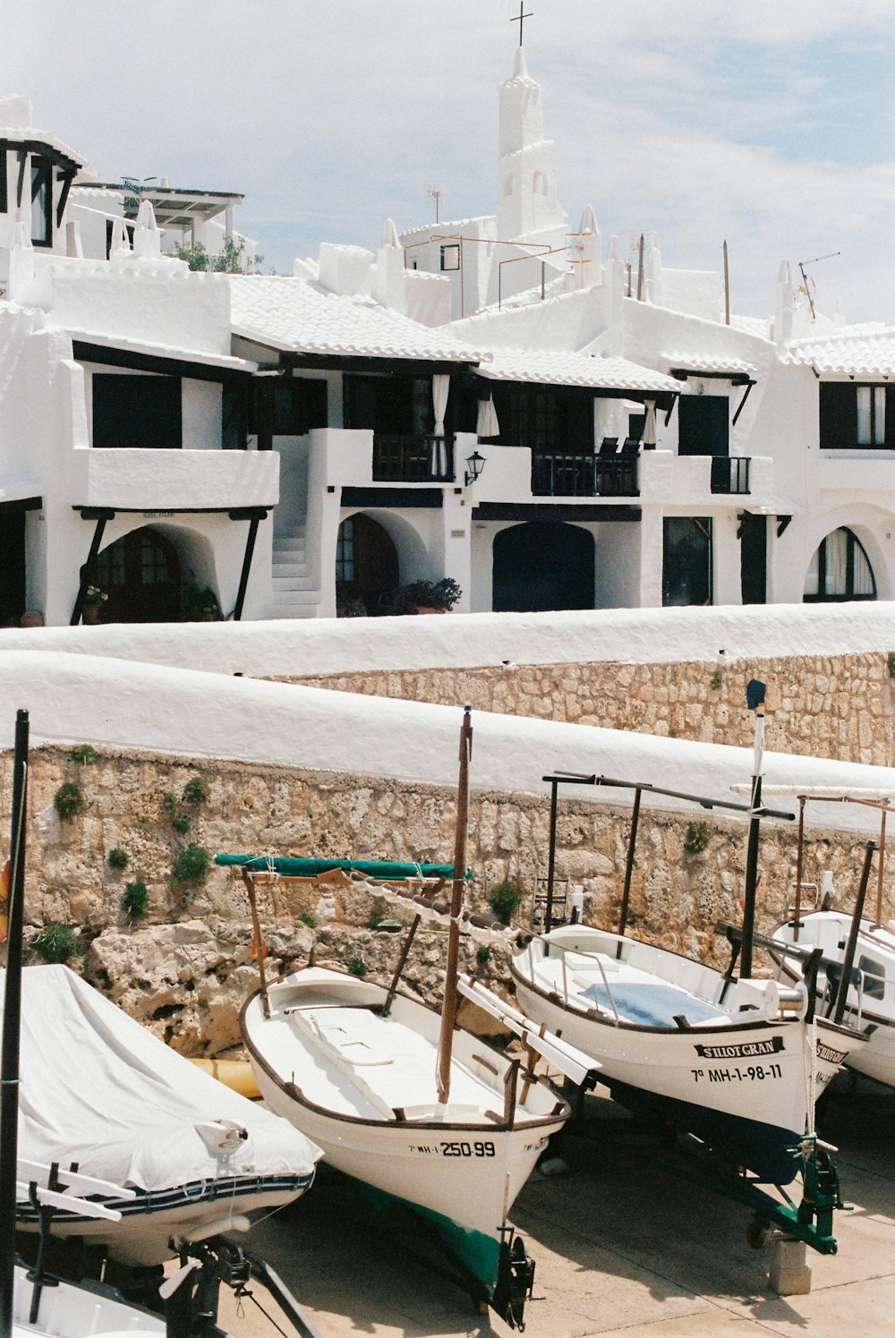 white and blue boat on white sand beach during daytime