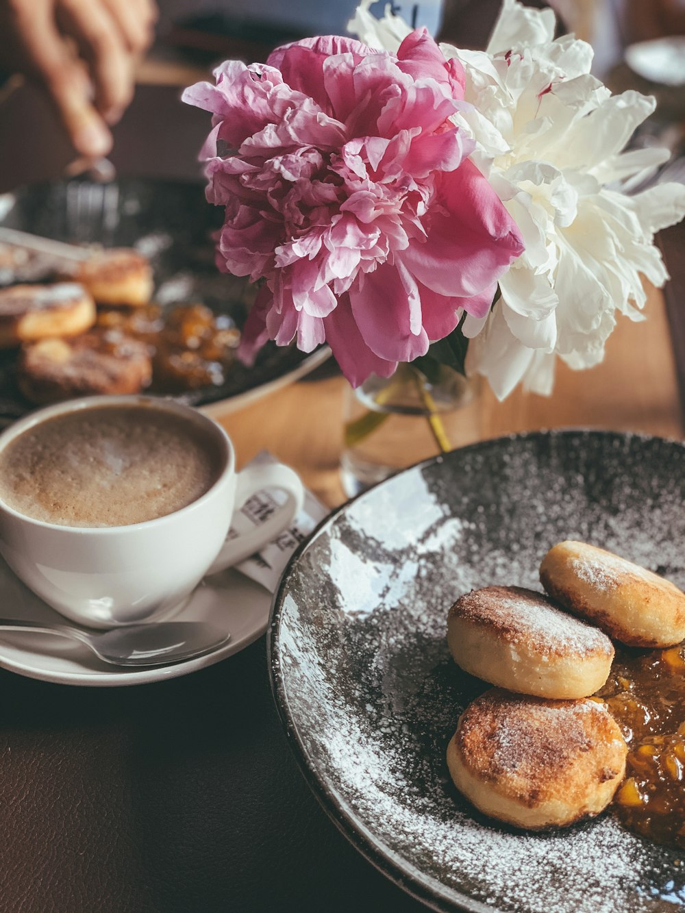 white ceramic cup on saucer beside bread