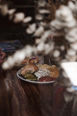 An inviting sandwich and bagel lunch spread on a garden-inspired tablecloth.