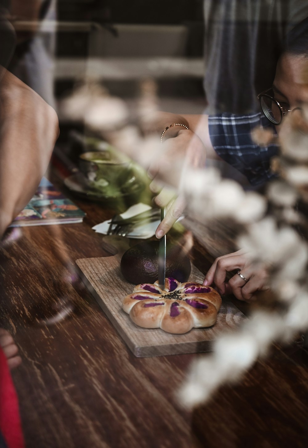 person holding burger on brown wooden table