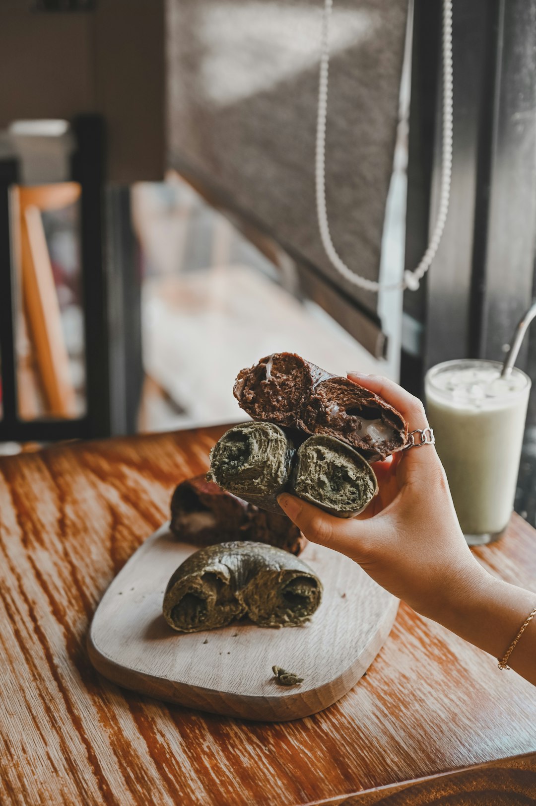 person holding chocolate cookies on white ceramic plate