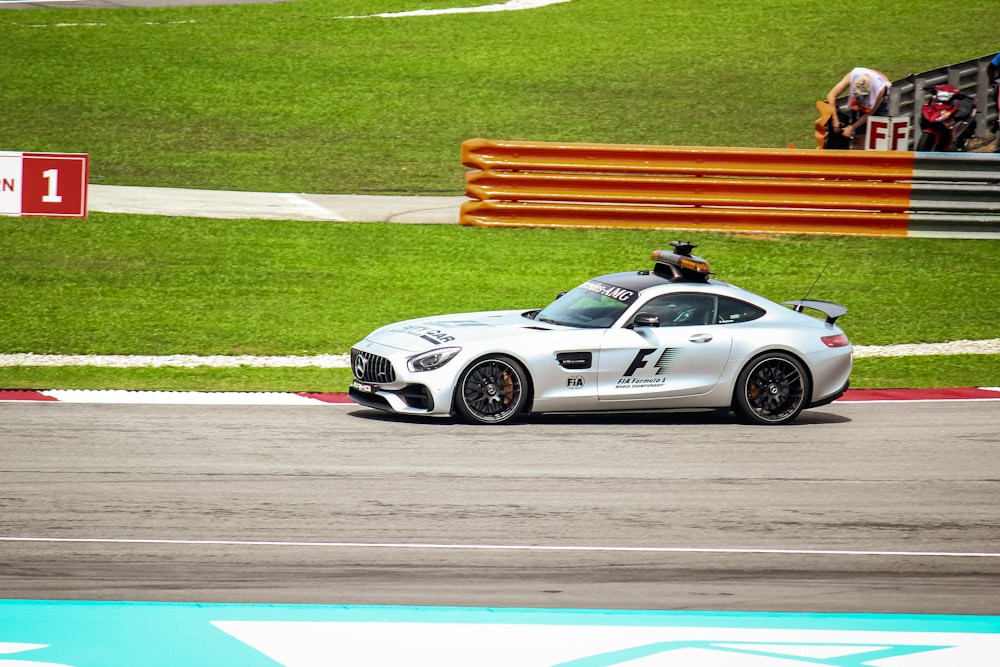 white and black porsche 911 on track field during daytime