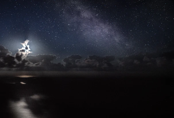 A serene night sky filled with twinkling stars and a glowing full moon casting a mystical light.