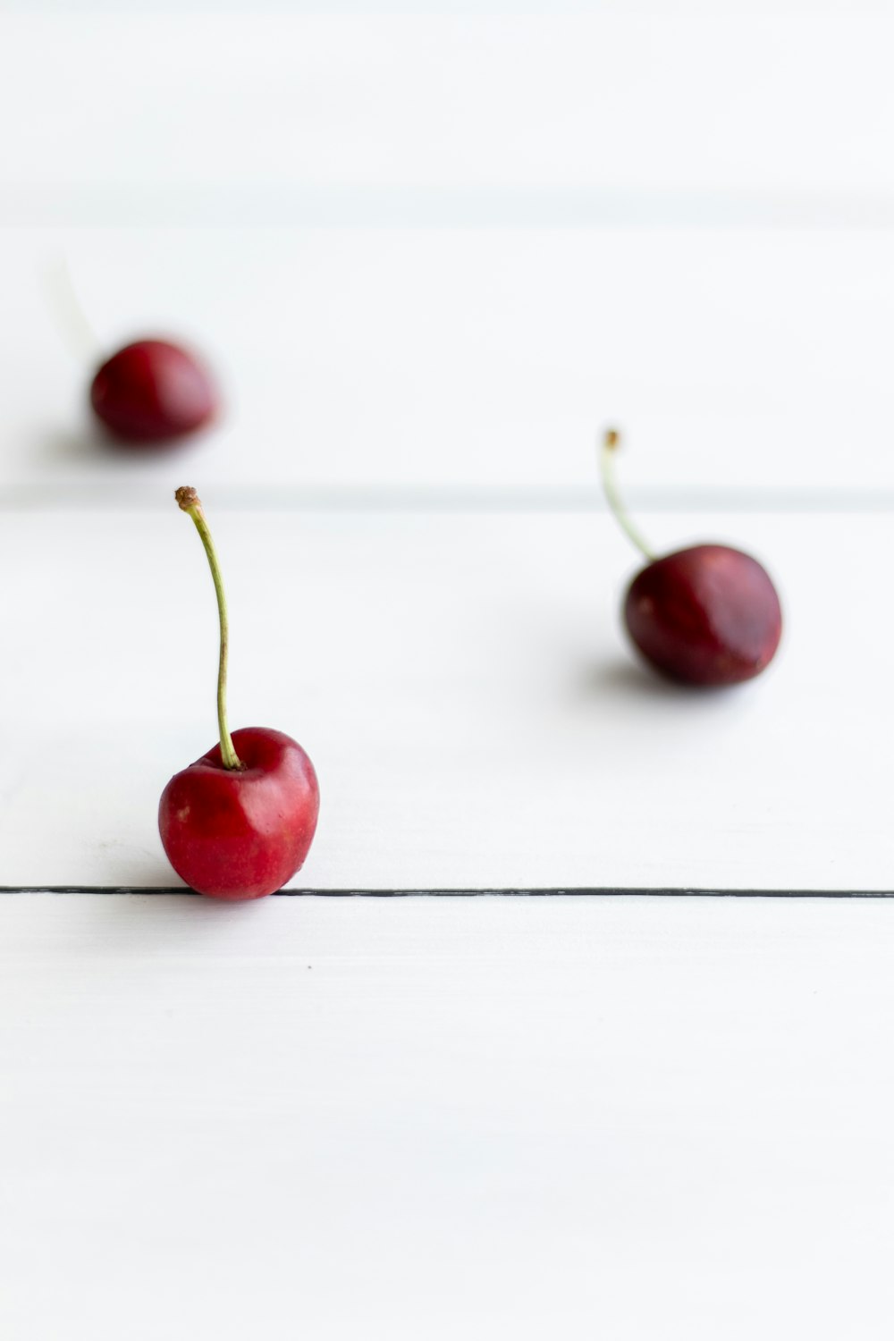 red cherry fruit on white surface