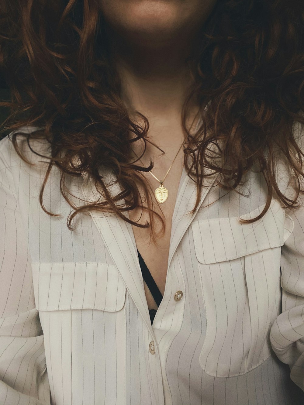 woman in white blazer with silver necklace