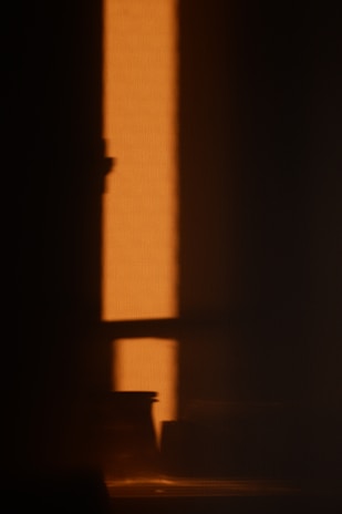silhouette of a person standing on a dark room