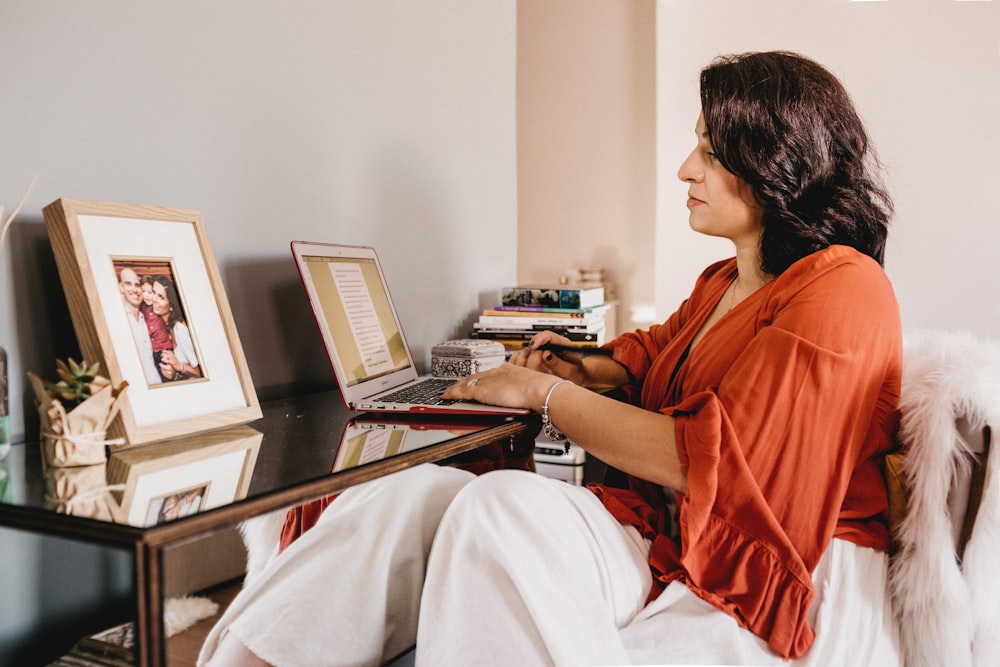 man in red shirt using laptop computer