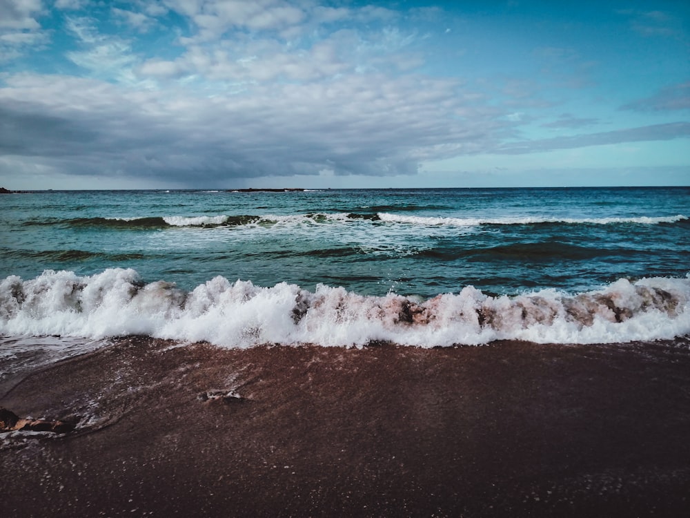 ocean waves crashing on shore during daytime