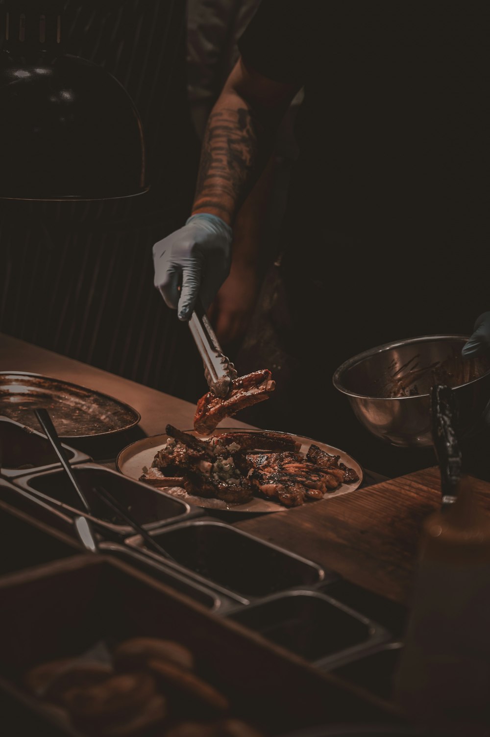 person holding knife slicing meat on brown wooden table