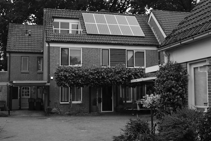 foto em preto e branco de uma casa com placa de energia solar residencial