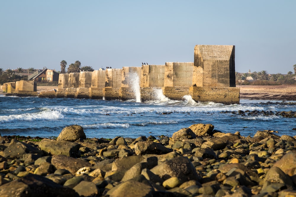 Bâtiment en béton brun près d’un plan d’eau pendant la journée