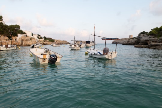 white and brown boat on body of water during daytime in Menorca Spain