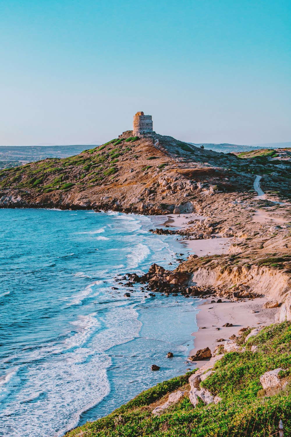 formação rochosa marrom no mar azul durante o dia