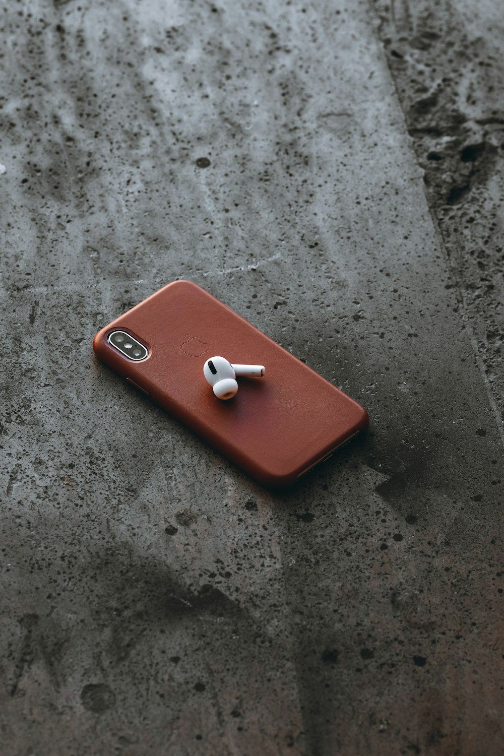 red iphone case on gray concrete floor