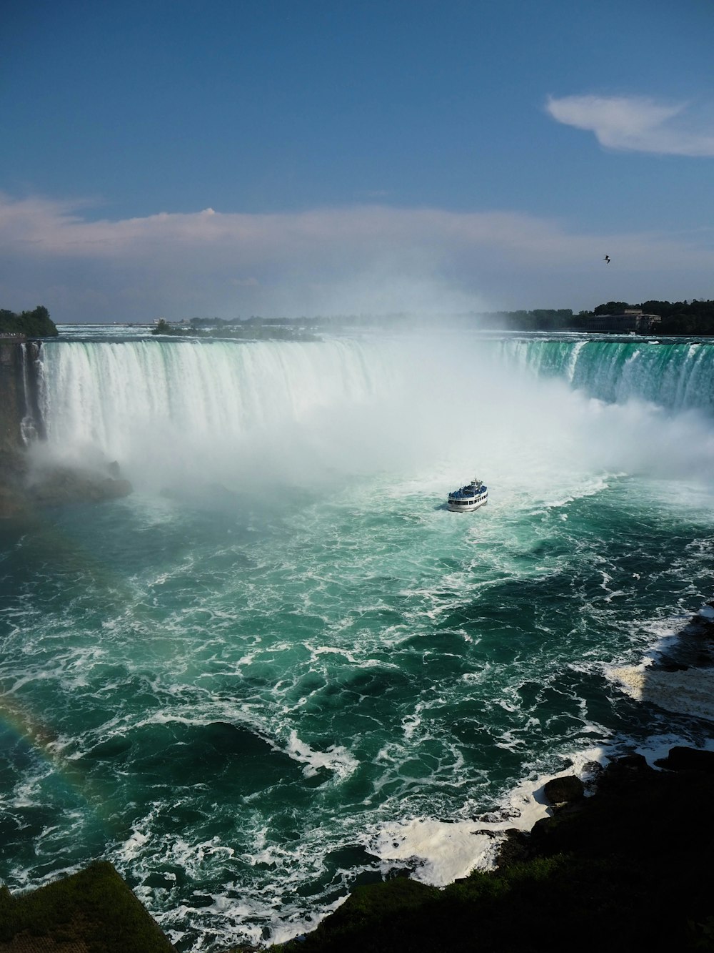 white boat on water falls during daytime