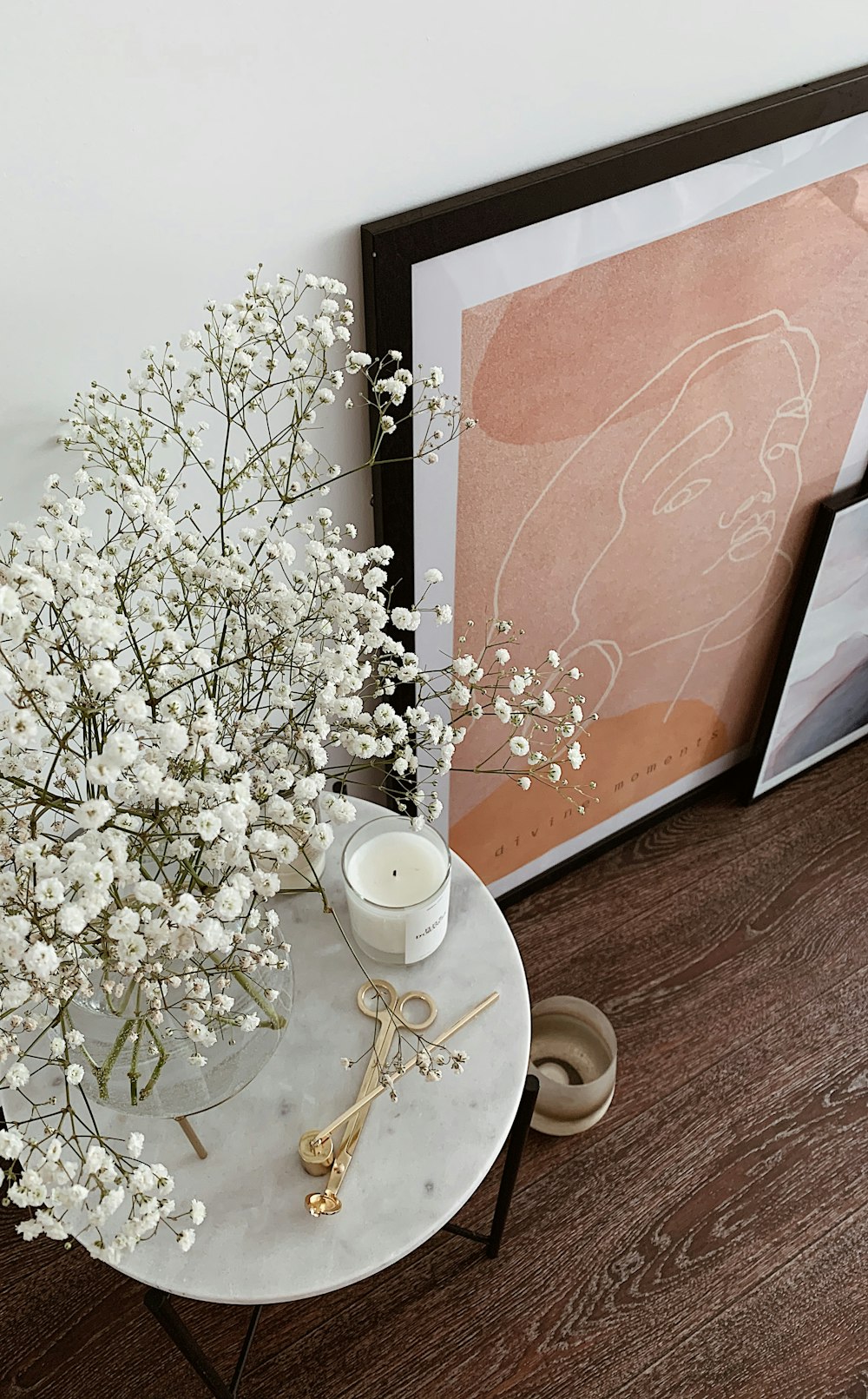 white flowers on white ceramic teacup on saucer beside brown leather bag