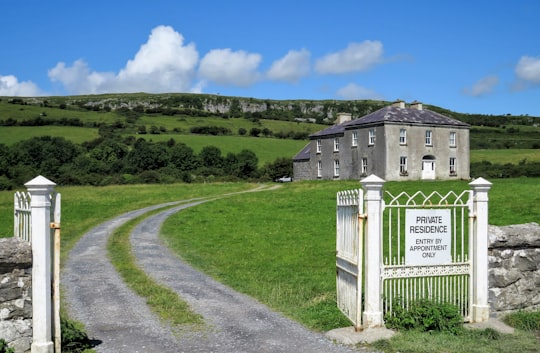 white wooden house on green grass field during daytime in Father Ted's House Ireland