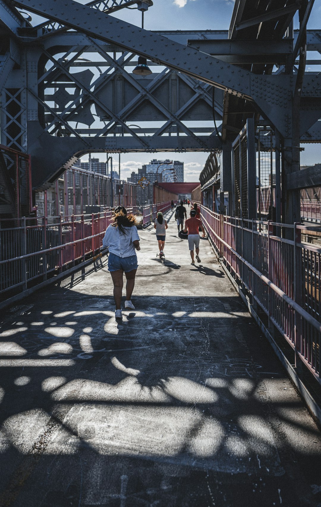 man in yellow t-shirt and blue shorts standing on bridge during daytime