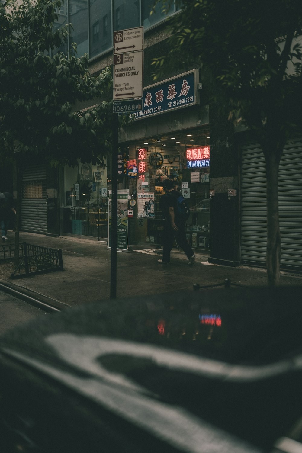 man in black jacket walking on sidewalk during night time