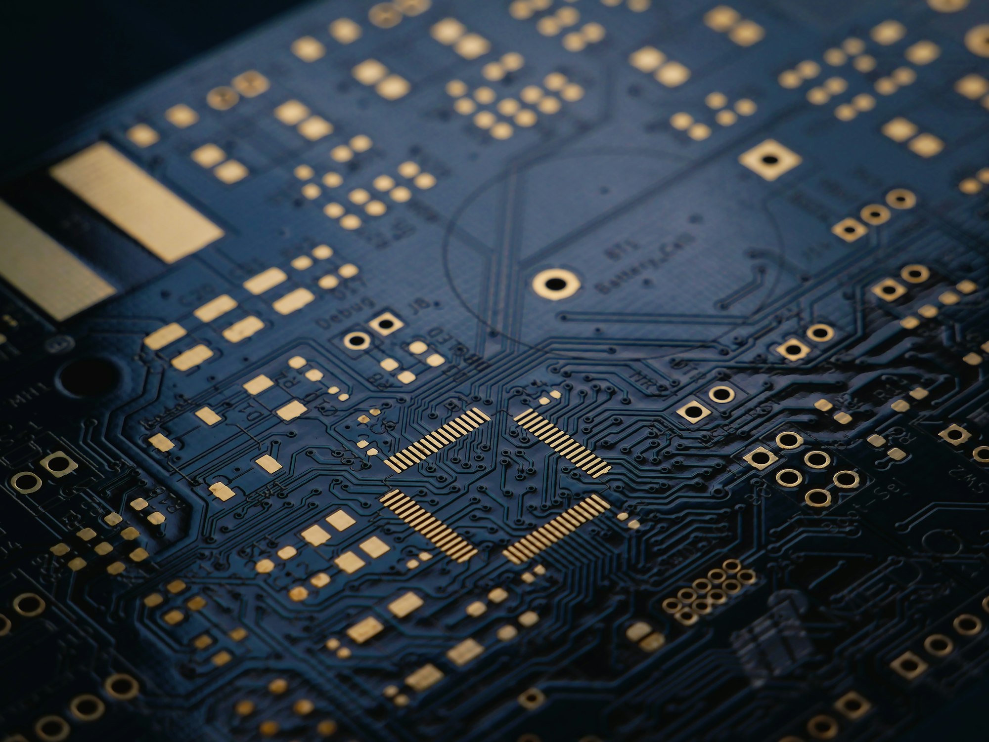 A low exposure photograph of an unsoldered Printed Circuit Board (PCB) with ENIG (Gold) finish.