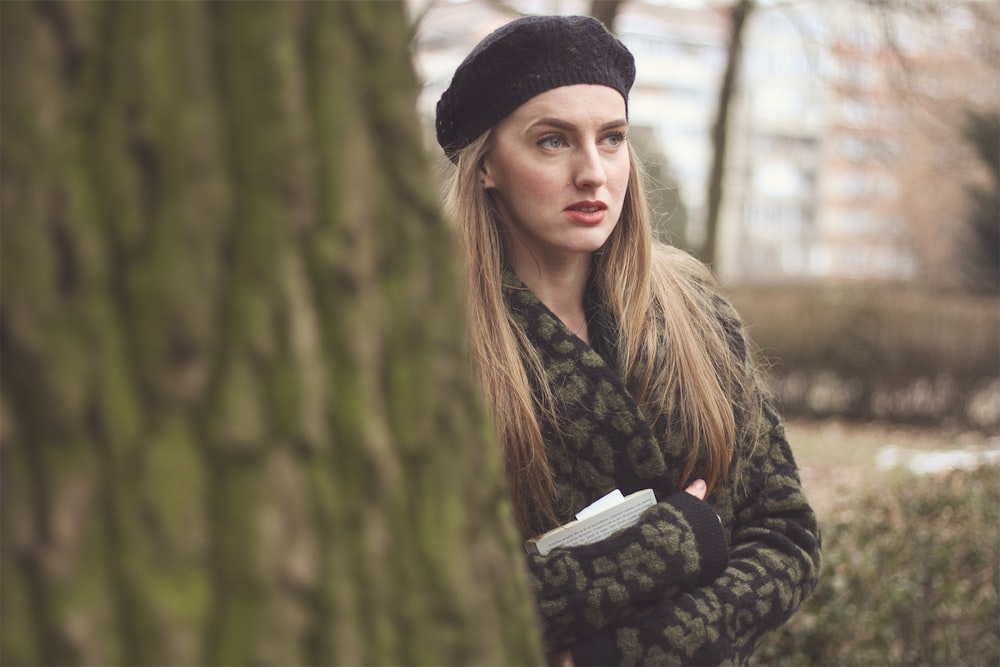 woman in black knit cap and green and black camouflage jacket