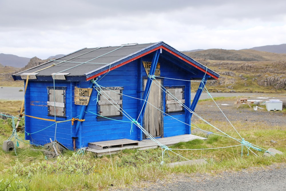 blue and white wooden house on green grass field during daytime