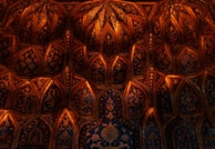 Close-up of intricate gold leaf patterns blending into a charcoal background.