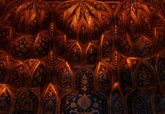 Close-up of intricate gold leaf patterns blending into a charcoal background.