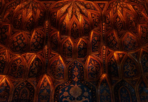 Delicate golden curves sweeping across a textured tan background, evoking a sacred creative studio ambiance.