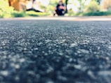 Close-up of a worn pavement with a translucent video frame of a daily commute superimposed.