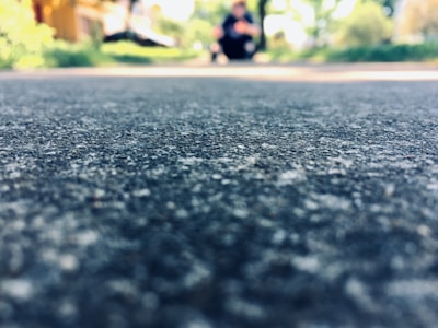 Close-up of a worn pavement with a translucent video frame of a daily commute superimposed.