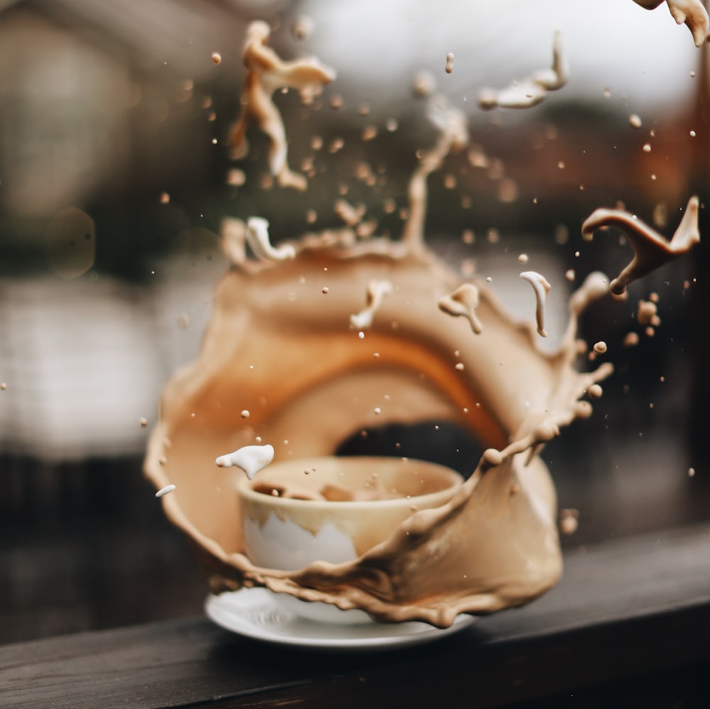 white ceramic teacup with brown liquid