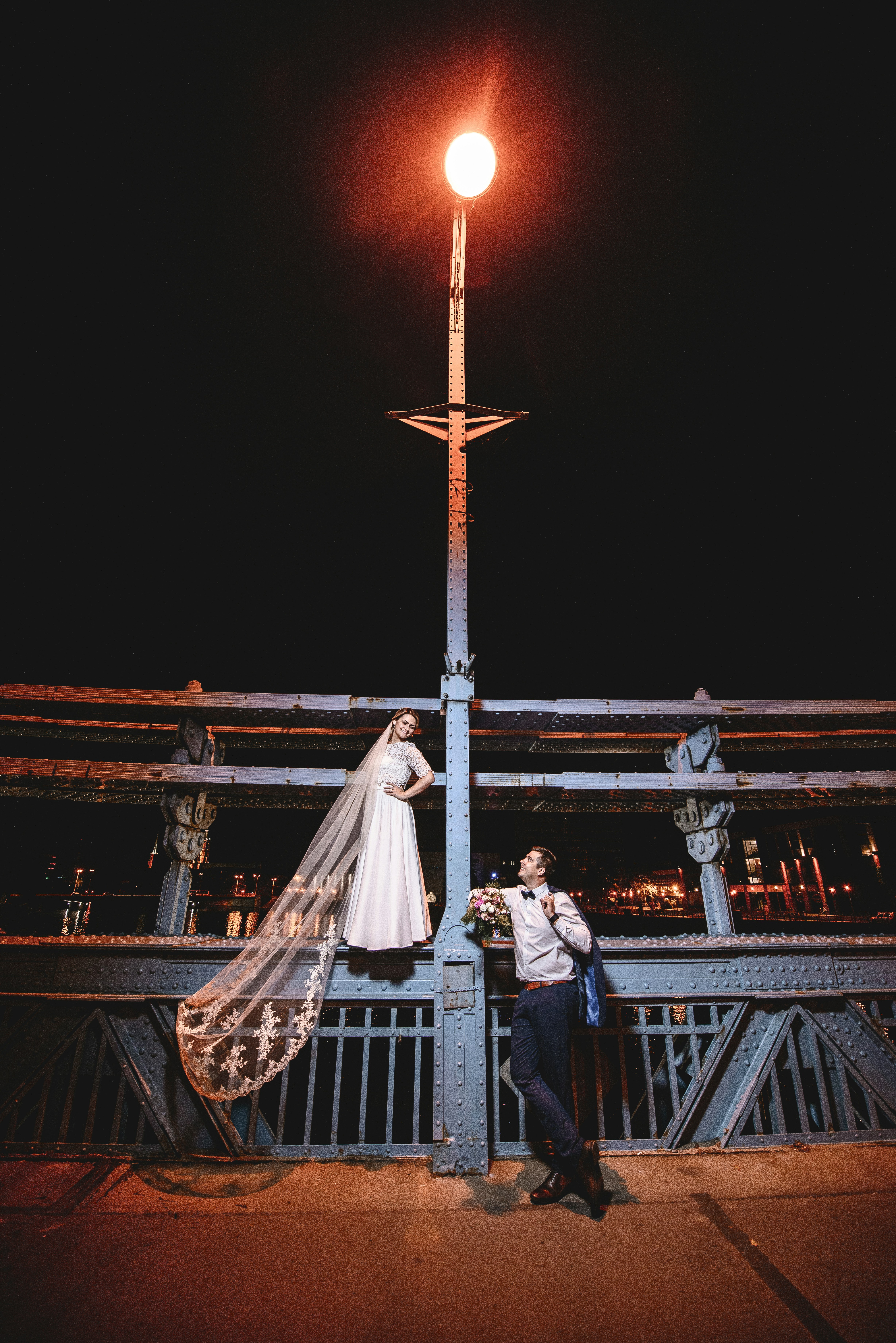 woman in white wedding gown standing beside man in black suit jacket