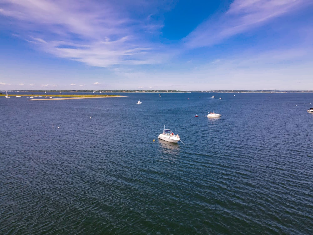 white boat on sea under blue sky during daytime