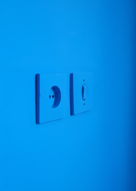white electric switch mounted on blue wall