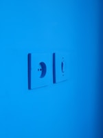 white electric switch mounted on blue wall