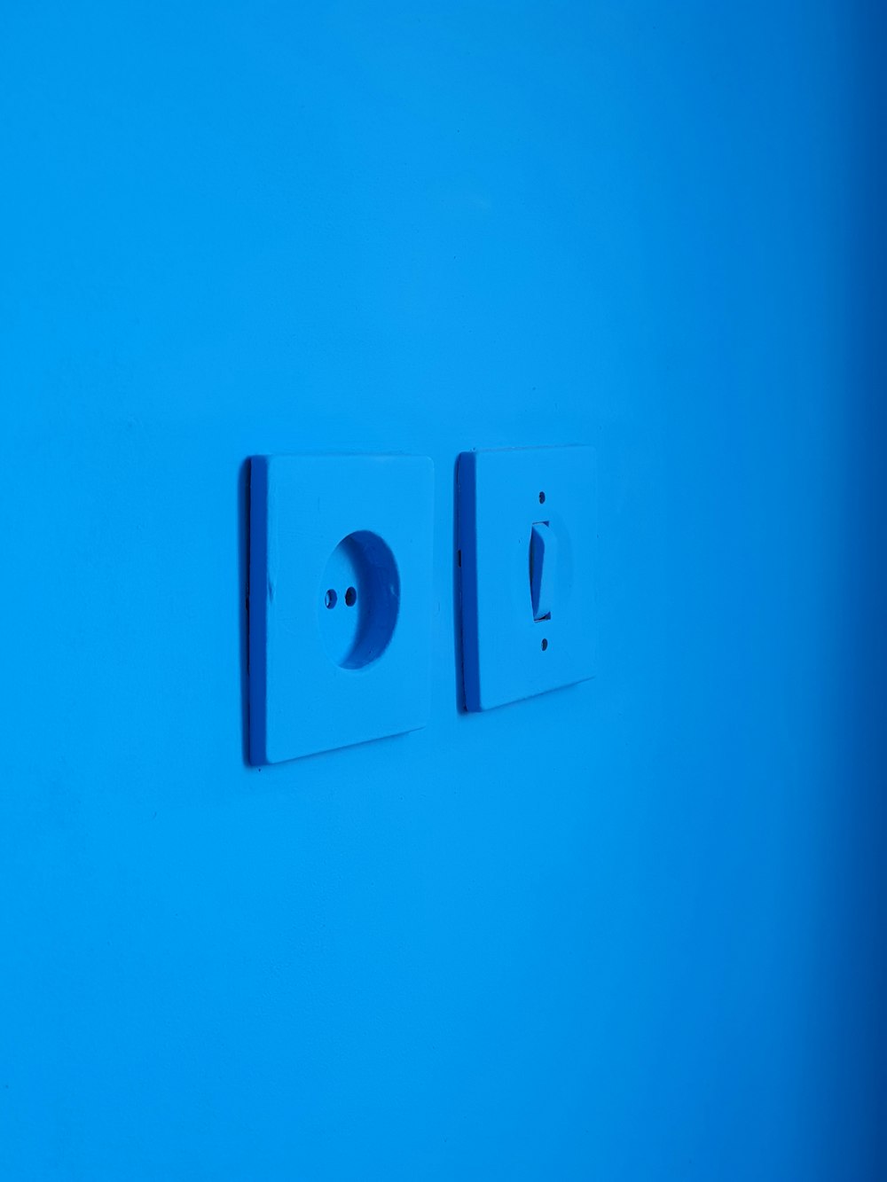 Interrupteur électrique blanc monté sur mur bleu