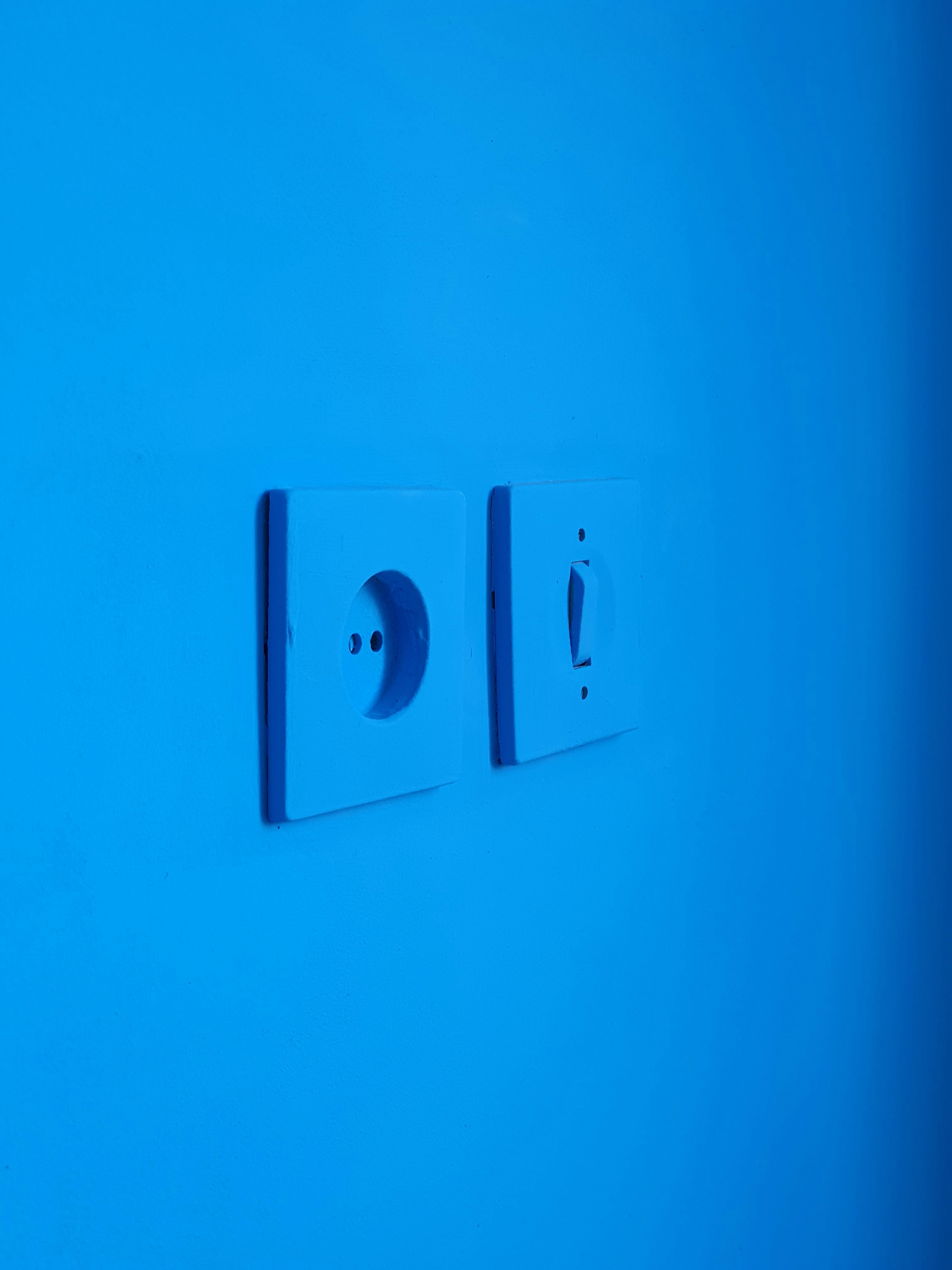 white electric switch mounted on blue wall