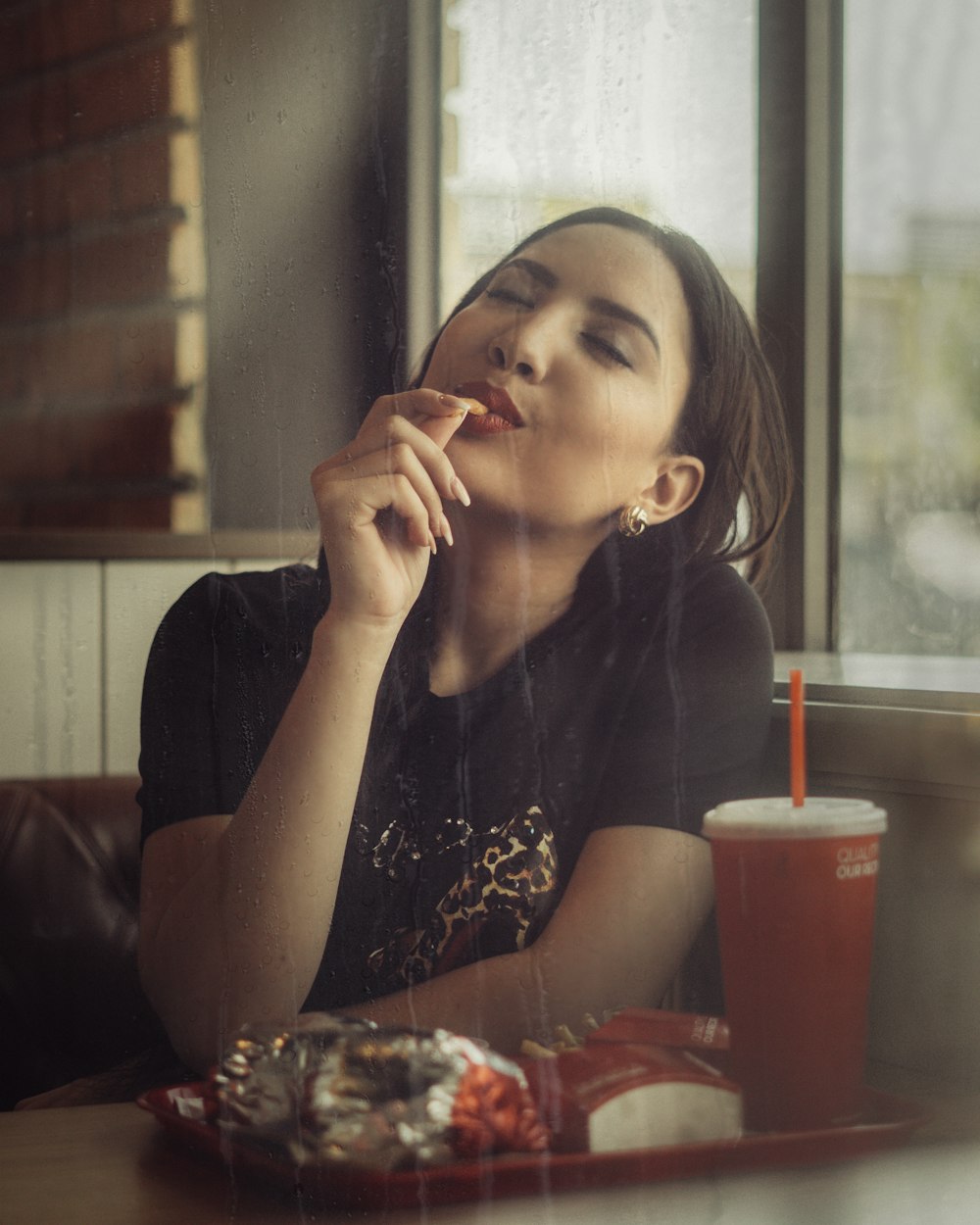 woman in black and white floral shirt sitting by the table