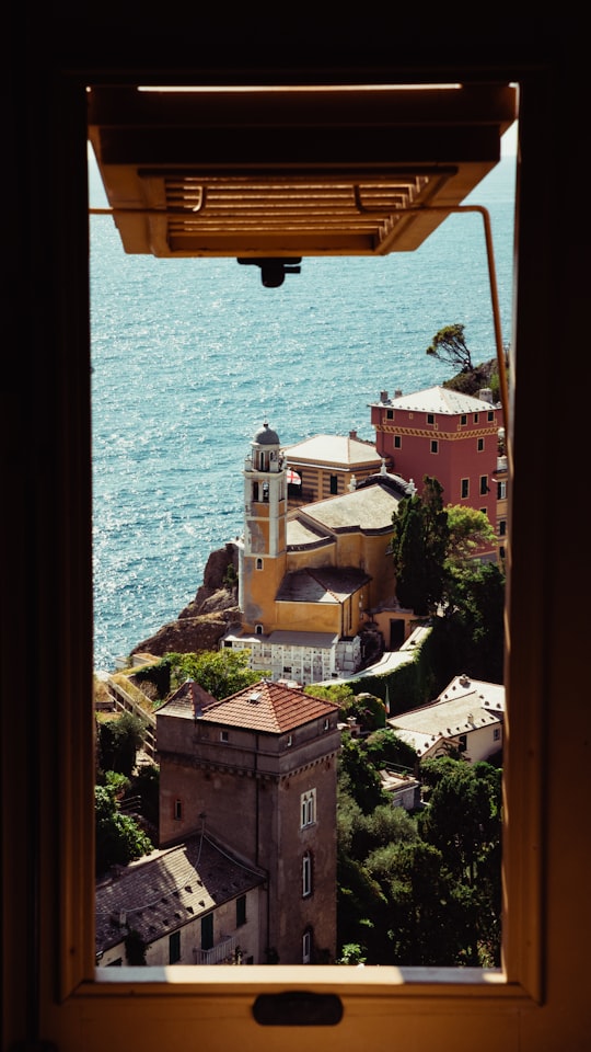 brown concrete building near body of water during daytime in Genoa Italy