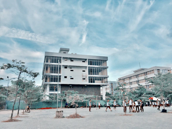 A bright, modern school building with students walking happily on a sunny day.