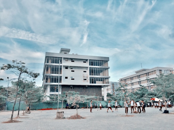 A panoramic view of Makerere University's iconic main building under a bright blue sky.