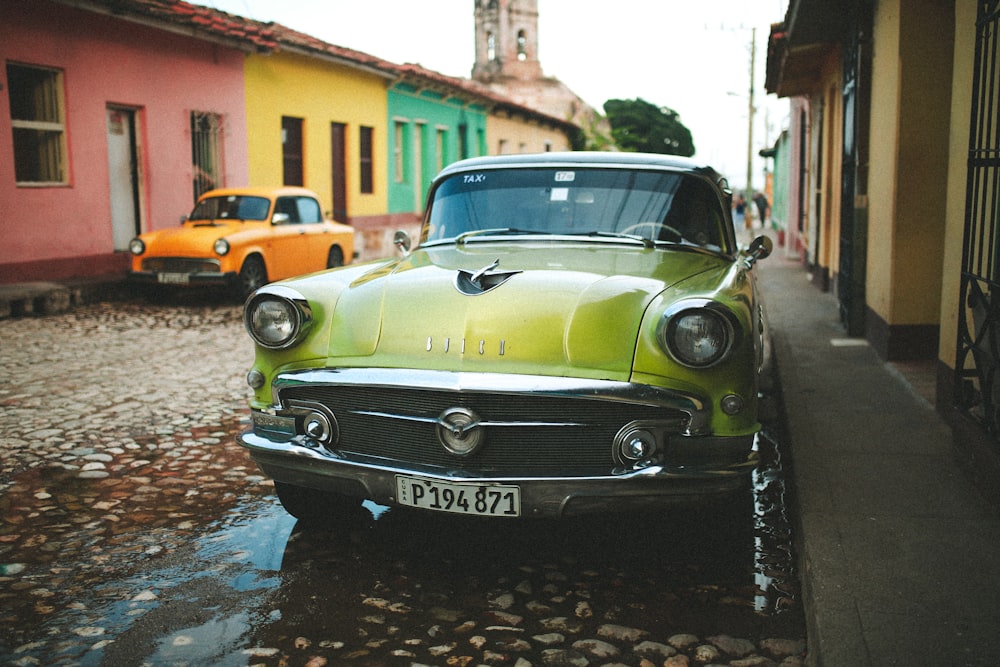 green classic car parked on the side of the road