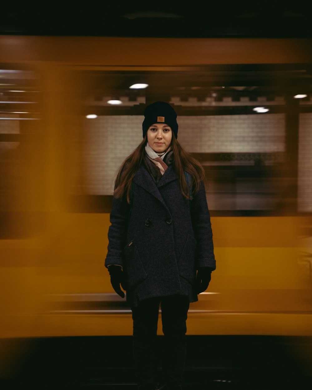 woman in black coat standing on train station